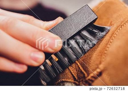 Hands cleaning men's camel suede desert shoe boot with a brush. Hands cleaning men's camel suede desert shoe boot with a brush. 72632718