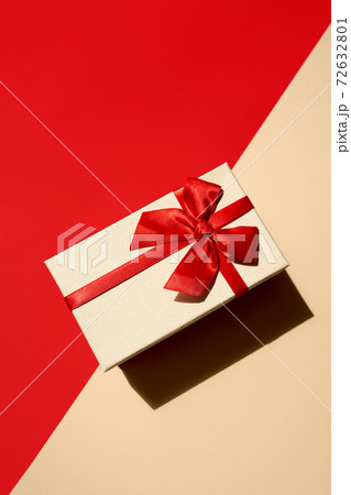 White present with red ribbon on the bright red background 72632801