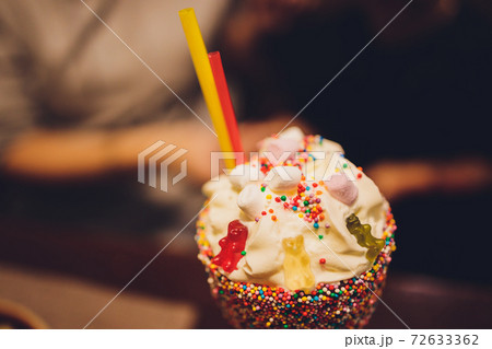 Glasses of milkshake, frappe, ice coffee and smoothie with whipped cream. 72633362
