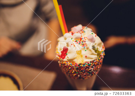 Glasses of milkshake, frappe, ice coffee and smoothie with whipped cream. Glasses of milkshake, frappe, ice coffee and smoothie with whipped cream. 72633363