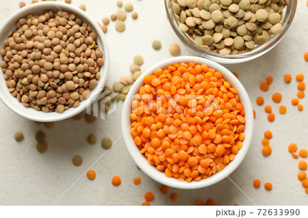 Bowls with different legumes on white textured background 72633990