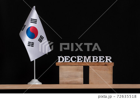 Wooden calendar of December with South Korea flag on black background. Dates of South Korea in December 72635518