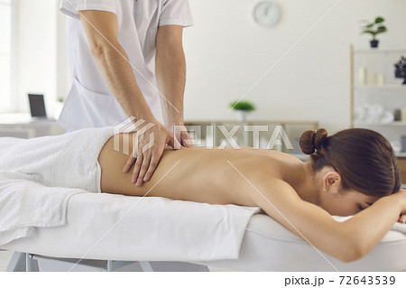 Professional doctor masseur during work with patient in medical clinic 72643539
