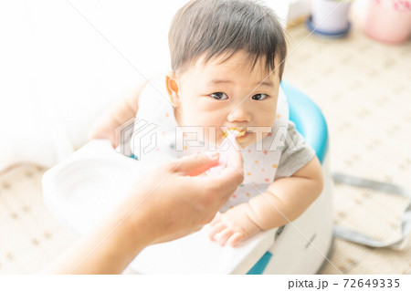 窓辺でベビーチェアに座って離乳食を食べる赤ちゃん 窓辺でベビーチェアに座って離乳食を食べる赤ちゃん 72649335
