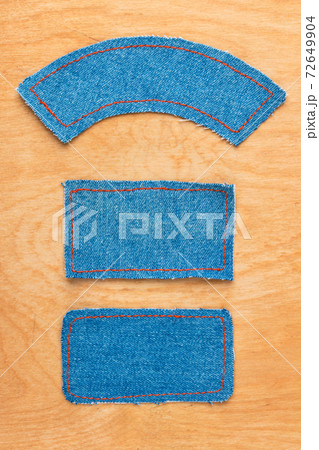 Price tags made of denim lying on wooden background. 72649904