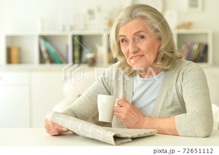 Close up portrait of senior woman reading newspaper 72651112