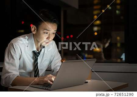 オフィスで夜遅くまで残業をするビジネスマン 72651290