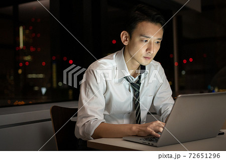 オフィスで夜遅くまで残業をするビジネスマン オフィスで夜遅くまで残業をするビジネスマン 72651296