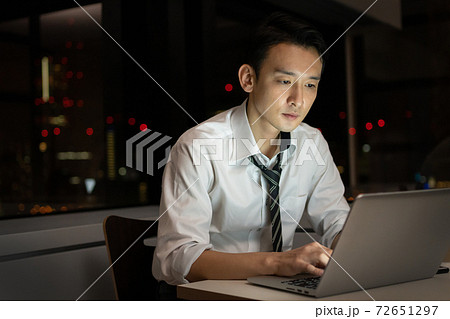 オフィスで夜遅くまで残業をするビジネスマン 72651297