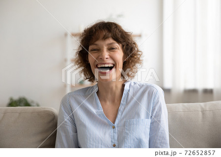 Overjoyed young female laughing on cute joke demonstrating perfect teeth Overjoyed young female laughing on cute joke demonstrating perfect teeth 72652857