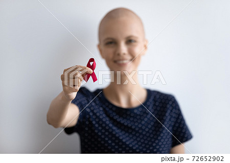 Young lady with oncology look at camera hold scarlet ribbon Young lady with oncology look at camera hold scarlet ribbon 72652902