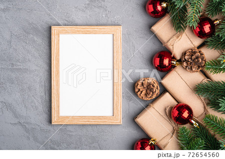 Christmas holidays composition with picture frame mockup. Red baubles, gifts and fir-tree branches. 72654560