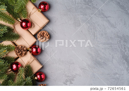 Christmas holidays composition. Red ornament and bauble decorations, fir-tree, gifts and pine cones. Copy space Christmas holidays composition. Red ornament and bauble decorations, fir-tree, gifts and pine cones. Copy space 72654561