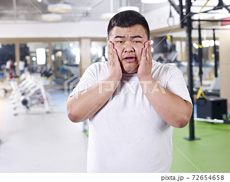 asian overweight man frustrated with boy weight in gym asian overweight man frustrated with boy weight in gym 72654658