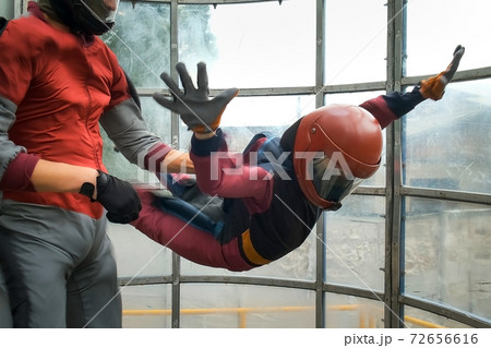Child boy with instructor is flying in aerodynamic tube, professional lesson.. Child boy with instructor is flying in aerodynamic tube, professional lesson.. 72656616
