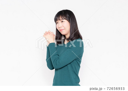 白背景の前でお願いのジェスチャーをする女性 白背景の前でお願いのジェスチャーをする女性 72656933