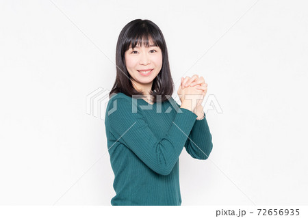 白背景の前でお願いのジェスチャーをする女性 白背景の前でお願いのジェスチャーをする女性 72656935