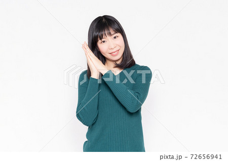 白背景の前でお願いのジェスチャーをする女性 白背景の前でお願いのジェスチャーをする女性 72656941