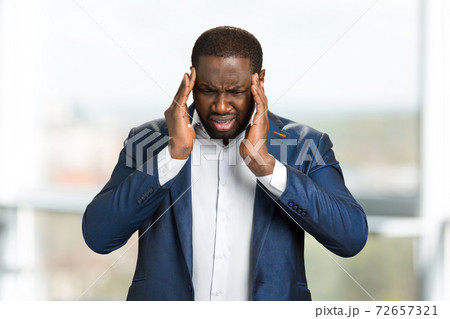 Young afro american businessman touching head. 72657321