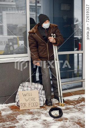 Old homeless man in a durty clothes in winter city Old homeless man in a durty clothes in winter city 72659327