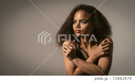 Scared and frightened girl stands covering herself with her hands crossed looking away. Stop violence against Women. Women violence and abused concept. trafficking Concept Scared and frightened girl stands covering herself with her hands crossed looking away. Stop violence against Women. Women violence and abused concept. trafficking Concept 72662670