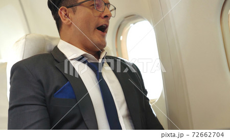 Sleepy businessman travel on a business trip by airplane Sleepy businessman travel on a business trip by airplane 72662704