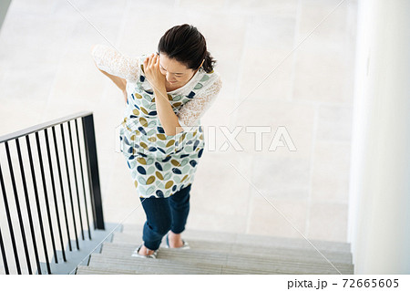 体の節節が痛くて階段を登ることが辛い女性 72665605