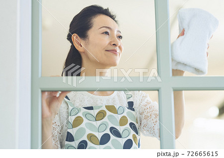 窓の拭き掃除をする主婦 72665615