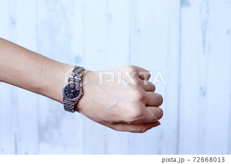 シルバーの腕時計をした女性の手元の写真素材