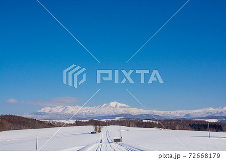 晴れた日の冬の丘陵地帯と雪山 大雪山の写真素材