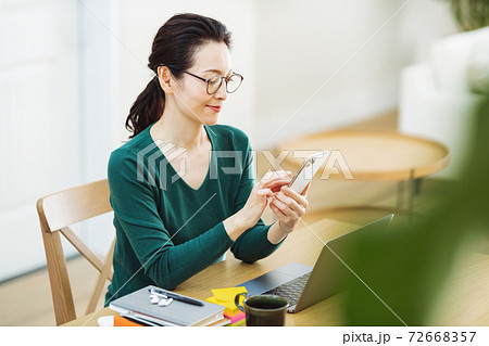 スマホを使うミドル女性 72668357