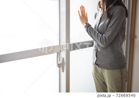 部屋の窓にもたれて外を眺める女性 部屋の窓にもたれて外を眺める女性 72669540