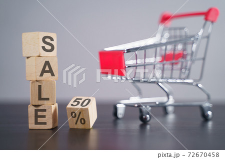 Text "SALE" on wooden cube with shopping cart. Text "SALE" on wooden cube with shopping cart. 72670458