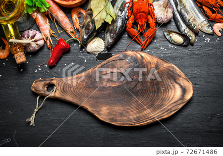 Cutting Board with a variety of shrimp, fish and shellfish. 72671486