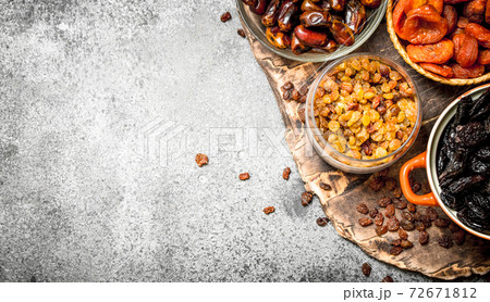 Various dried fruit in bowls. 72671812