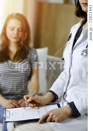 Close-up of woman-doctor and patient discussing current health examination while sitting indoors. Stay at home concept during Coronavirus pandemic and self isolation quarantine. Covid 2019 Close-up of woman-doctor and patient discussing current health examination while sitting indoors. Stay at home concept during Coronavirus pandemic and self isolation quarantine. Covid 2019 72671941