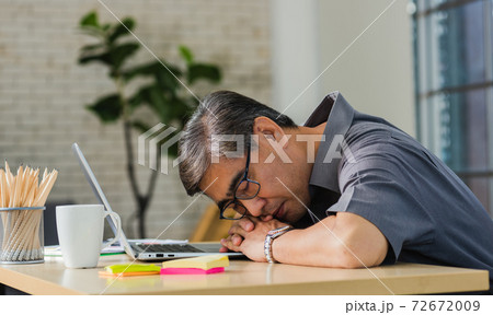 businessman tired overworked he sleeping over a laptop computer businessman tired overworked he sleeping over a laptop computer 72672009