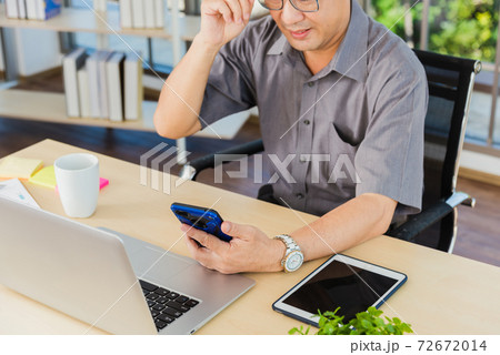 Old businessman using the mobile phone to video call conference Old businessman using the mobile phone to video call conference 72672014