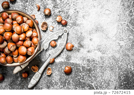 Hazelnuts in a bowl with a Nutcracker. 72672415