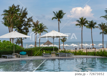Beautiful swimming pool next to the palm tree beach 72673052