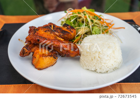White plate of grilled pork ribs with rice and salad 72673545