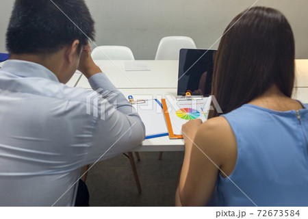 Disappointed business people feeling stressed, looking at laptop 72673584