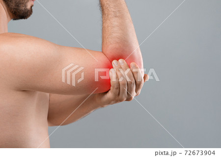 Cropped of topless man suffering from painful elbow 72673904
