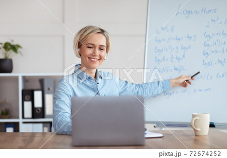 Young university teacher giving mathematics class online from home, explaining logarithms to college students 72674252