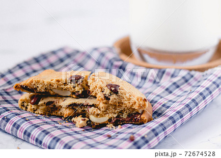 Chocolate cookies on napkin and blur glass of milk background on marble table Chocolate cookies on napkin and blur glass of milk background on marble table 72674528