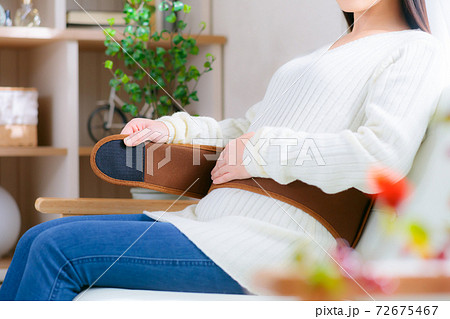 温活　ベルトを巻いて腰を温める女性　 72675467