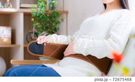 温活　ベルトを巻いて腰を温める女性　16:9 72675468