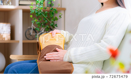 温活する女性　サポーターベルトに湯たんぽを入れる　16:9 72675479