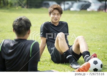 公園でサッカーをする若い男性 公園でサッカーをする若い男性 72675516