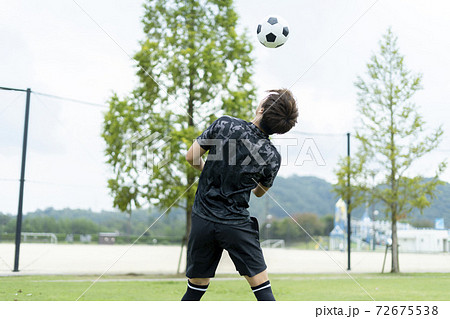 公園でサッカーをする若い男性 72675538